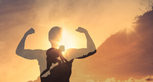 image shows the shadow of a man climbing a surface superimposed over him flexing
