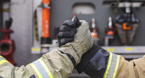 image shows the hands of two firefighters grasping each other